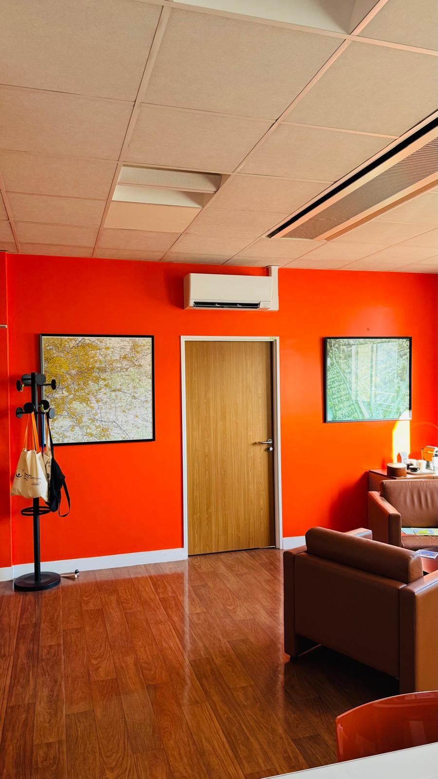 Split mural Mitsubishi Electric installé dans un bureau aux murs orange
