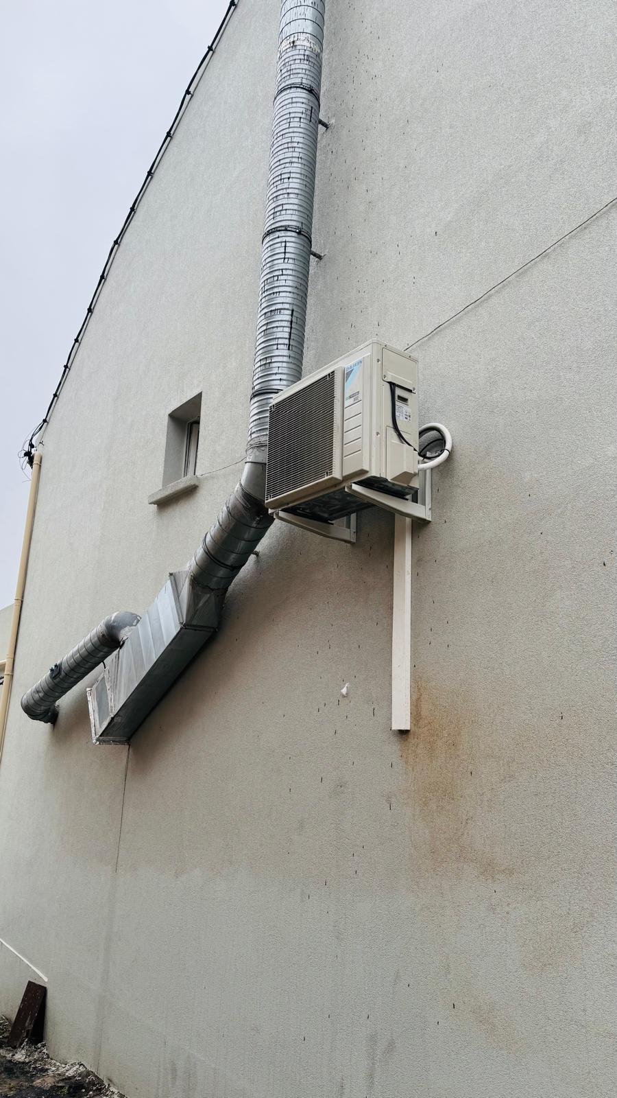 Unité extérieure Daikin et gaine VMC installées sur façade de bâtiment