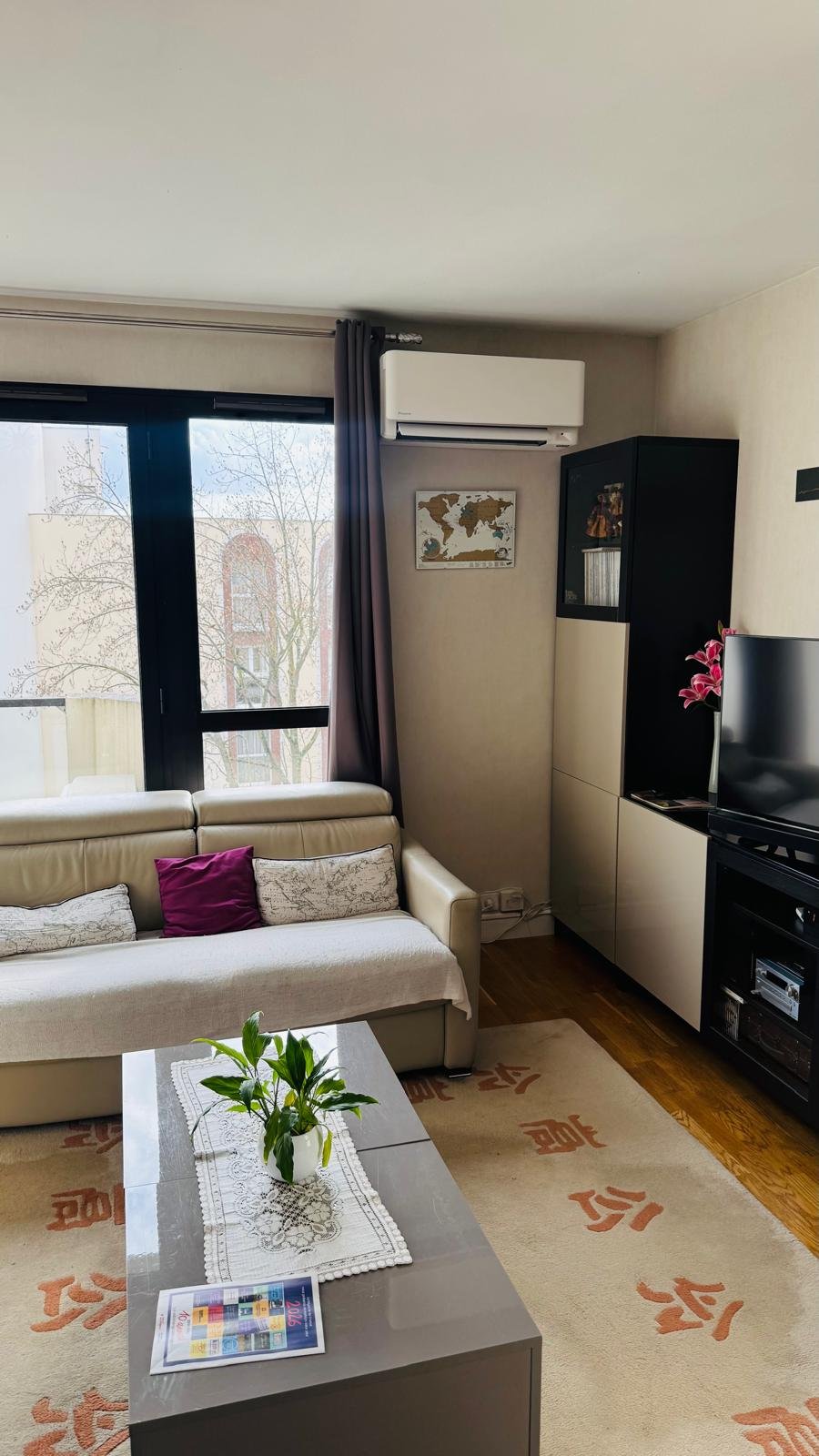 Split mural dans un salon résidentiel avec canapé beige et TV