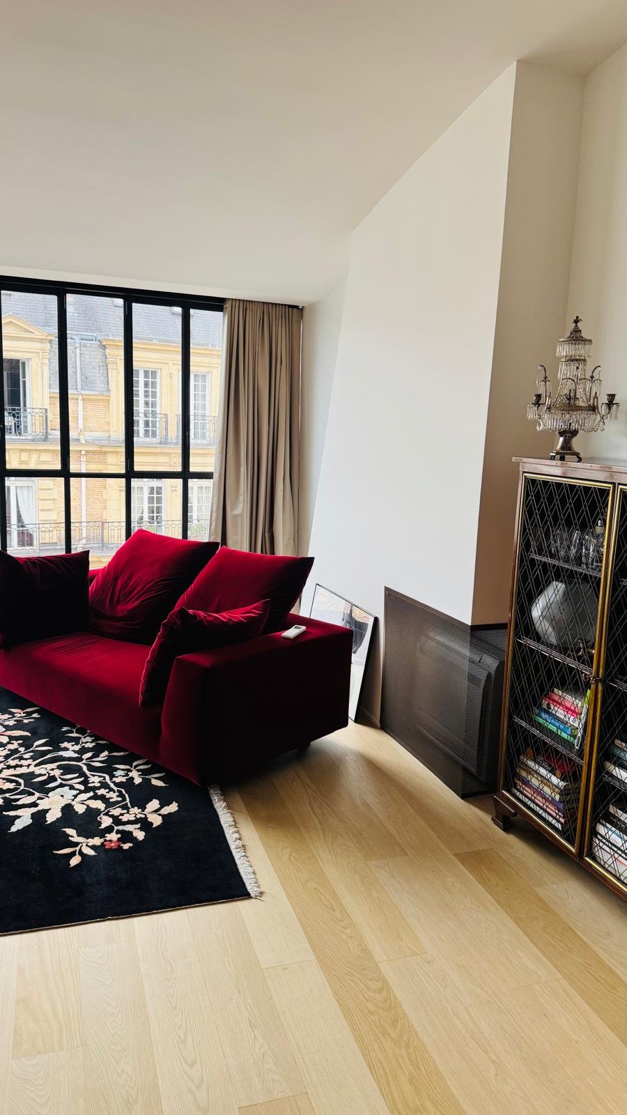 Split mural installé dans un salon haut de gamme parisien avec canapé rouge velours