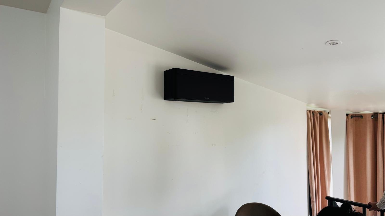 Split mural Daikin coloris noir installé dans un salon résidentiel